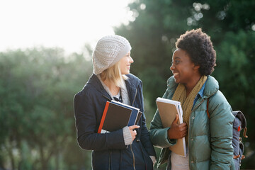 Education, books and conversation with woman friends outdoor on campus together for learning or...