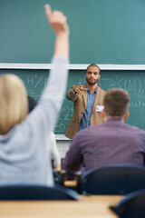 Teacher, students and question in lecture hall, university and professor with information and feedback. People, education and college with knowledge and learning with answer and ideas with solution © Nicola K/peopleimages.com