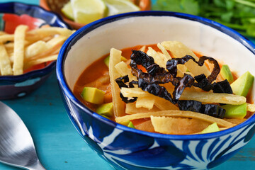 メキシコのトルティージャのスープ　ソパ・デ・トルティージャ（ソパ・アステカ）コピースペースあり　青背景
 Mexican tortilla soup　Sopa de Tortilla (Sopa Azteca）with copy space, blue background