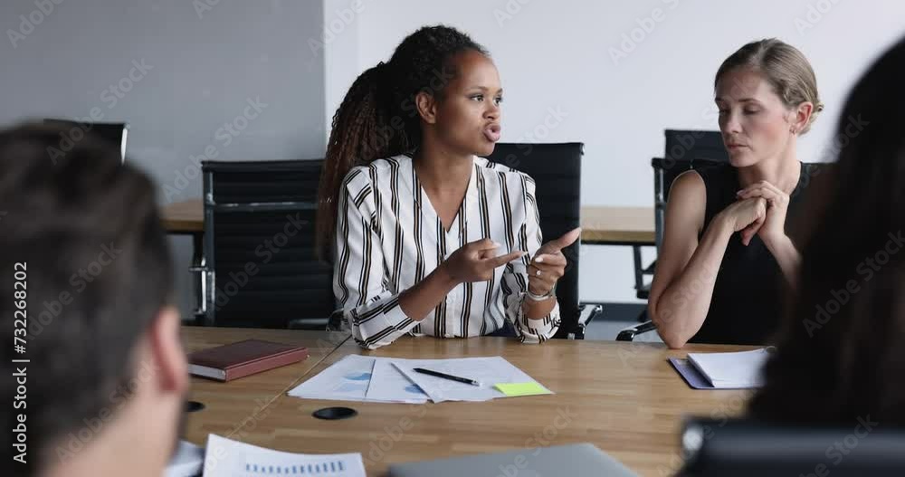 Sticker Serious pretty young African American businesswoman talking to listening nodding colleagues on brainstorming meeting, sharing creative ideas, project strategy vision, counting on fingers, speaking