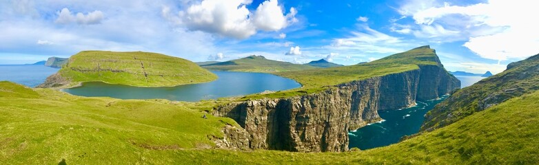 Landscape panorama Sorvagsvatn lake on cliffs of Vagar island, Faroe Islands, Denmark. Lake above the ocean. a lake on the edge of an abyss. Hiking and travel concept.