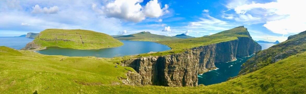 Landscape panorama Sorvagsvatn lake on cliffs of Vagar island, Faroe Islands, Denmark. Lake above the ocean. a lake on the edge of an abyss. Hiking and travel concept.