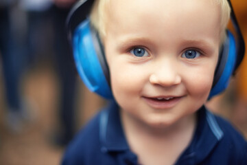 Baby, closeup and smile for portrait with headphones for noise at outdoor festival, happy and cute...