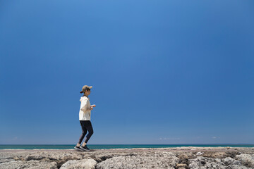 沖縄の海岸をジョギングする女性