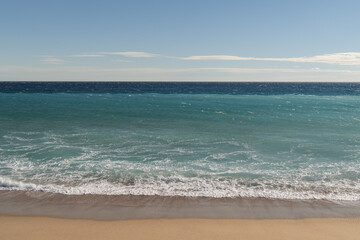 Warm day on a Cannes beach with azure waves of mediterranean sea