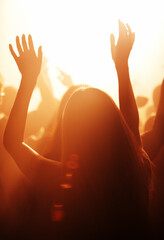 Woman, live and festival with arms raised to listen, music and dance with crowd, cheering and dancing to performance on stage. Audience, enjoy and singing with loud, sound and partying with band.
