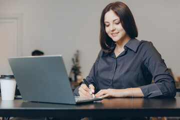 Young female use notebook student doing assignments in cafe, student lifestyle