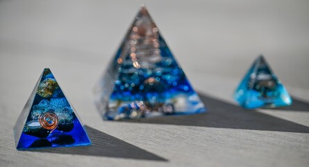 Isolated close up of three beautiful blue orgone generator pyramids- Israel