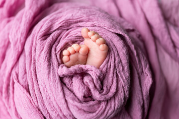 newborn baby feet on pink background
