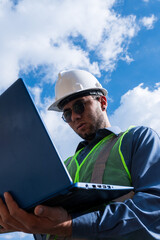 Engineer man working and looking laptop in sunny day