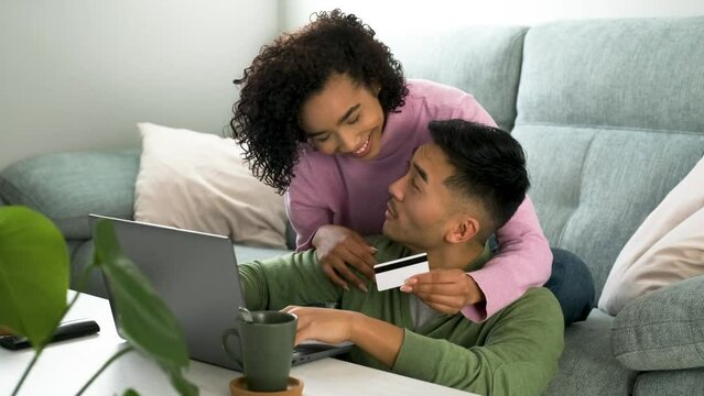 Multiracial happy couple shopping online, making a travel reservation.