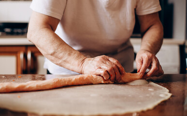 Person preparing pastries from dough with pumpkin