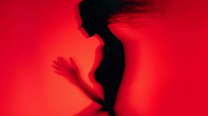 Female blurred silhouette on a red background. Elegant outline of a woman in motion out of focus