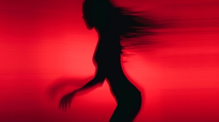 Female blurred silhouette on a red background. Elegant outline of a woman in motion out of focus