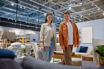 Woman with her husband looking for furniture in store