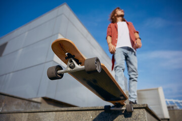 Closeup longboard under hipster guy foot, extreme riding preparation