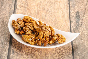 Cracked unshelled walnut in the bowl