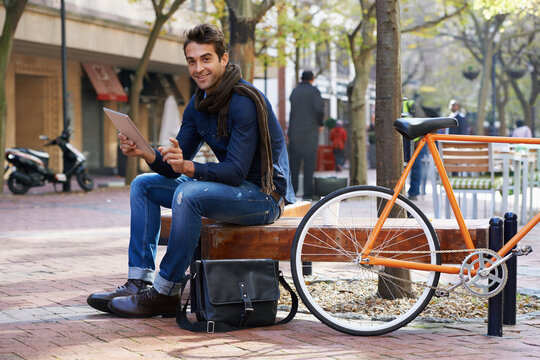 Portrait, city and smile with man, tablet and bicycle with adventure and travel with internet and social media. Person, outdoor and New York with guy and technology with connection and meme with app
