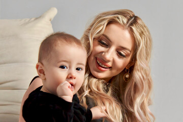 mother and child, Beautiful sexy blonde mother in a beige jacket and with a baby son