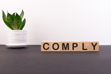 COMPLY word made with building blocks on a light background