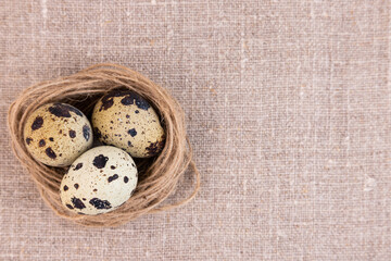 Traditional easter nest with eggs on a linen surface.