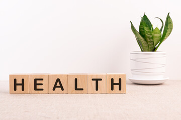 Health word on wooden cubes on a light table with flower and a light background