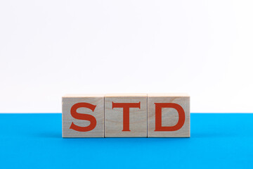 STD inscription on wooden cubes on a blue background
