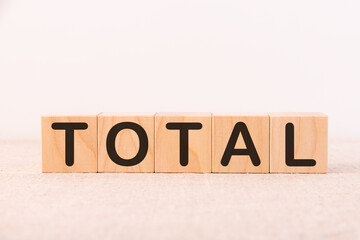 Total word concept written on wooden cubes on a light table