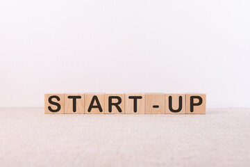 Start up word concept written on wooden cubes on a light table
