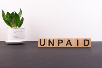 UNPAID word made with building blocks on a light background