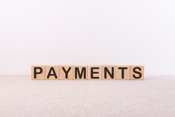 Payments word concept written on wooden cubes on a light table and light background
