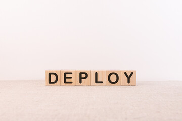 Deploy word written on wooden cubes on a white background.