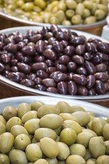 Fresh olives in barrels on street market or in grocery shop. Snack containing vitamins