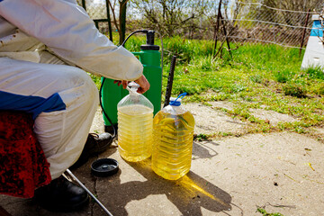 Farmer is blending substance with water in proper scale to sprinkles fruit trees