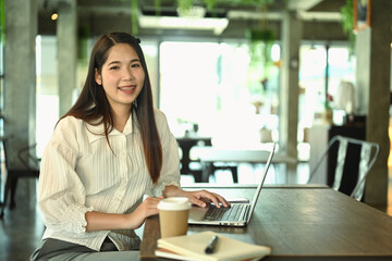 Portrait of beautiful businesswoman using laptop at startup business office