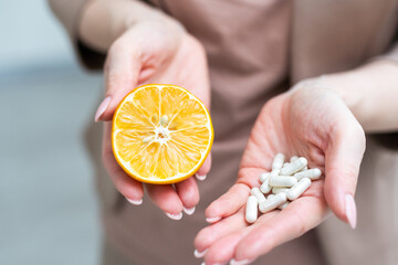 Hand holding Medicine Pills vs a Fruit on a white background. Natural Health or Medicine