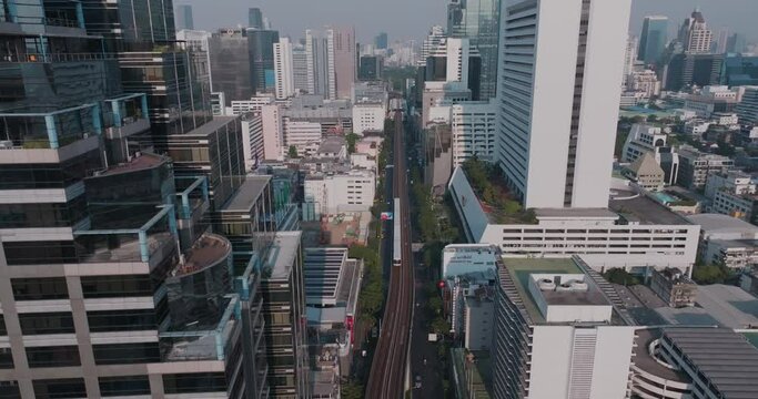 Aerial view modern office city building with BTS sky train and city road in Silom district Bangkok Thailand transport industry