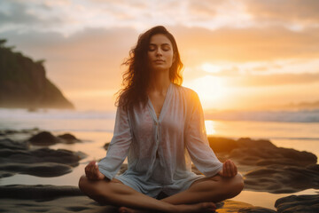 Fototapeta na wymiar Serene woman meditating on beach at sunset. Mindfulness and relaxation.