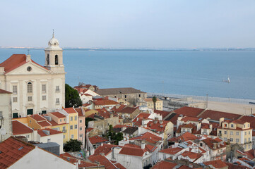Fototapeta premium Vista del barrio de Alfama y la iglesia de San Estevao junto al río Tajo en la ciudad de Lisboa, Portugal