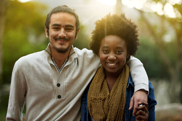 Park, portrait and happy interracial couple together with trees, sunshine and morning embrace with love. Romance, smile and date in nature, man and woman hug with diversity, connection and care. - obrazy, fototapety, plakaty