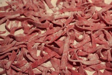 Tagliatelle, pasta, homemade, tradition, traditional, Close-up of homemade italian traditional pink beetroot Tagliatelle pasta with flour. Raw itialian pasta also called fettuccine or tagliatelle