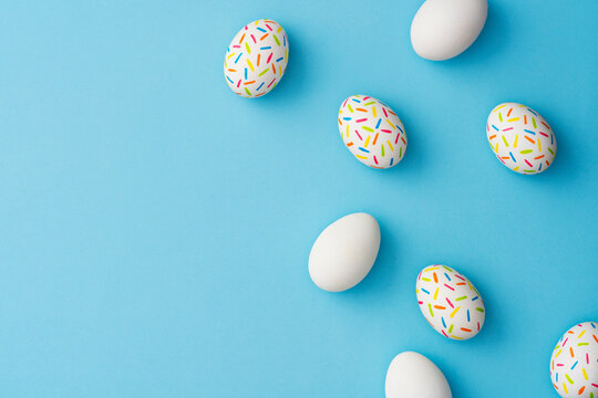 Sprinkle painted colorful easter eggs on blue background