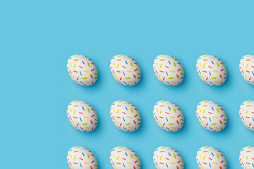 Sprinkle painted colourful easter eggs on blue background