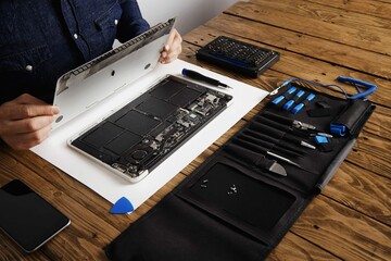 Service Man Opens Backside Topcase Cover Computer Laptop Before Repairing Cleaning Fixing It With...