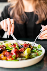 Obraz na płótnie Canvas woman hands with knife and fork eat Fresh salad
