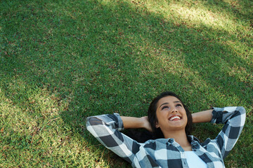 Mockup, park or happy woman on grass to relax for rest in garden, nature or field for peace. Space, travel or female person on break with smile on outdoor summer vacation or holiday on lawn in USA