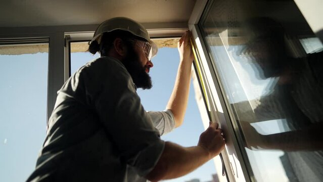 Worker replacing an old window with new plastic window . Apartment renovation	