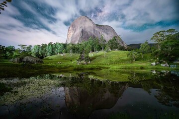 Tranquil, picturesque landscape featuring a lush forest with a mountain peak reflecting in a lake