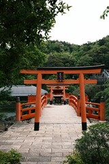 Vertical of a torii against a bridge and a traditional Japanese Sinto shrine