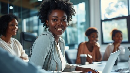 Young African American female entrepreneurs teamwork looking at camera working with technology laptop in modern workplace. businesswomen engage in discussion meeting, Confidence and collaboration work
